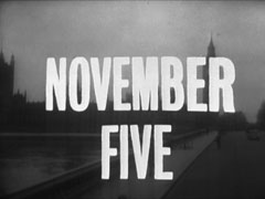 title card: white all caps text reading ‘NOVEMBER FIVE’ superimposed on a shot across Westminster Bridge towards the Houses of Parliament and Big Ben
