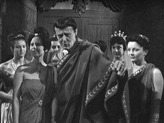 Sir Bruno leads his courtesans into the revel, dressed in an emperor’s toga