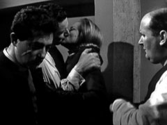 Maintaining the facade, Steed and Cathy kiss when they’re caught together in the kitchen by Harry and Sid (left and right respectively)