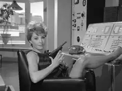 Auntie’s receptionist draws a Luger pistol when she hears Steed outside the door