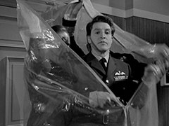 The officers zip themselves into a huge plastic bag in an attempt to thwart enemy listening devices