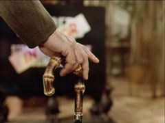 Close-up of Steed’s hand holding the Malacca cane handle of his umbrella - the depth of field is narrow and the background is out of focus