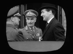 Psev’s monitor screen shows Steed being greeted by two generals at the conference