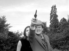 Steed takes aim at the imcoming model aeroplane with his revolver