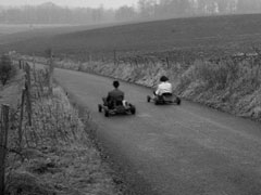 Steed and Emma drive away from Manton House in go-karts