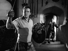 Steed, sword and targe in hand, turns to face Angus as Roberton appears in the door behind him and takes aim with his revolver