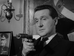 Steed cold-bloodedly takes aim with a silenced pistol