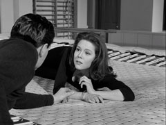 Emma lies on the trampoline in a black leotard as she discusses events with Steed