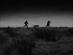 Saul chases after Smallwood with his hunting dogs in a stark silhouette
