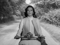 Emma drives as they ride off on a Vespa motor scooter (back projection scene)