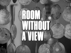 title card: white all caps text reading ‘ROOM WITHOUT A VIEW’ outlined in black and superimposed on a close-up of a Chinese disc wind chime