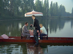 Sam and Steed enjoy a light lunch on board a punt in the river, their waiter is wearing waders
