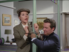 Steed and Emma are handcuffed to the bedpost, Steed tries to pick the cuffs with a gold tie pin