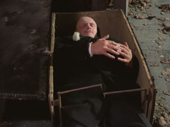Lucas lies in the box, a white carnation left by the groom lying across his chest