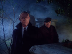 Masgard and Tom gaze melevolently at Steed in the shadows of the foggy graveyard