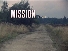 title card: white all caps text outlined in black reading ‘MISSION...’ superimposed on a view of a deserted, dusty country lane