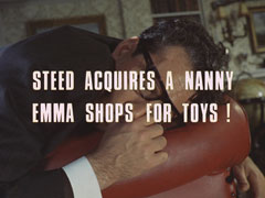 subtitle card: white all caps text with black dropshadow to the left reading ‘STEED ACQUIRES A NANNY
			EMMA SHOPS FOR TOYS’ superimposed on a close-up of Dodson slumped over a red leather armchair, dead and sucking his thumb