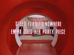 subtitle card: white all caps text with black dropshadow to the left reading ‘STEED FLIES TO NOWHERE
			EMMA DOES HER PARTY PIECE’ superimposed on a view from further down the round corridor, now predominantly red
