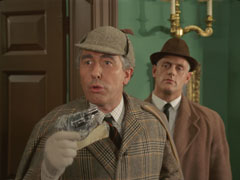Sir Doyle holds up the plastic-bagged revolver, one of his detectives stands behind him