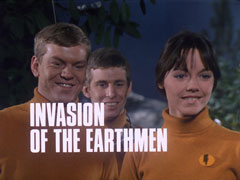 title card: white all caps text reading ‘INVASION OF THE EARTHMEN’ superimposed on three students in orange rollnecks looking just to the right of the camera, smiling maliciously