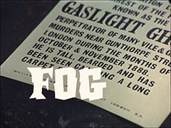 title card: white all caps text in a jagged font reading ‘FOG’ superimposed on a police warning lying on the black cobblestones. The warning reads: ‘[100 Guineas Reward for information leading to the arr]est of the [person] known as the GASLIGHT GHOUL perpetrator of many vile & g[risly] murders near Gunthorpe Stre[et] London during the months of October & November 1888. He is tall, bearded and has been seen carrying a long carpet bag’