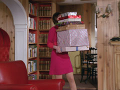 Tara is almost complete hidden behind the huge pile of parcels she carries in to Steed’s living room