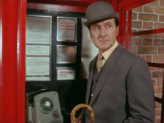 Steed checks to see no-one’s watching after entering the red phone box which is the secret door into Mother’s office