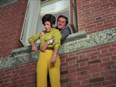 Steed grabs Tara by the waist after she attempted to leap out a window after being brainwashed by Bromfield