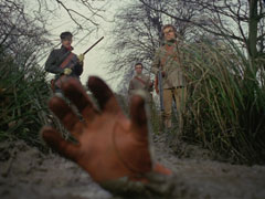 Steed’s right gloves is all that remains above the surface of the marsh; the villains look on grimly