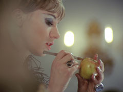 Circe, in profile, practices her scalpel technique on an apple