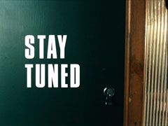 title card: white all caps text reading ‘STAY TUNED’ superimposed on Steed’s dark green, closed front door