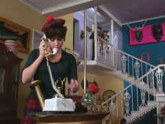 Tara is on her old-fashioned white and brass phone as Steed enters her door at the top of the stairs